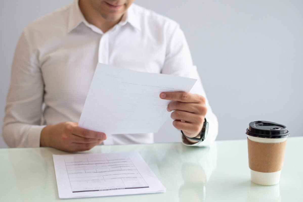 close-up-smiling-young-businessman-looking-document.jpg